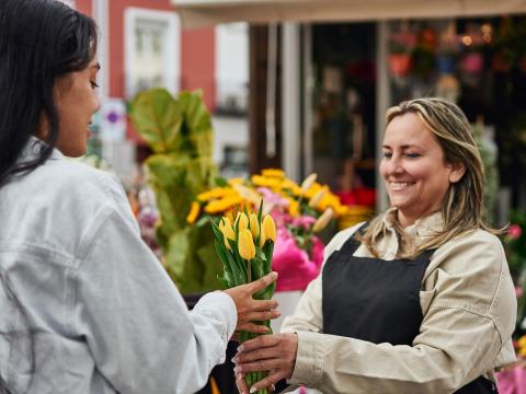 fleuriste qui donne un bouquet à une cliente